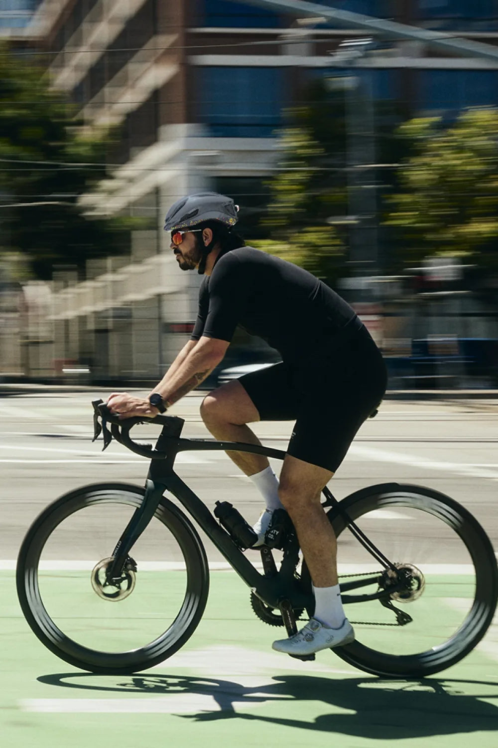 Rider on a road bike in a city bike lane wearing Lumos Aero GT in Pop